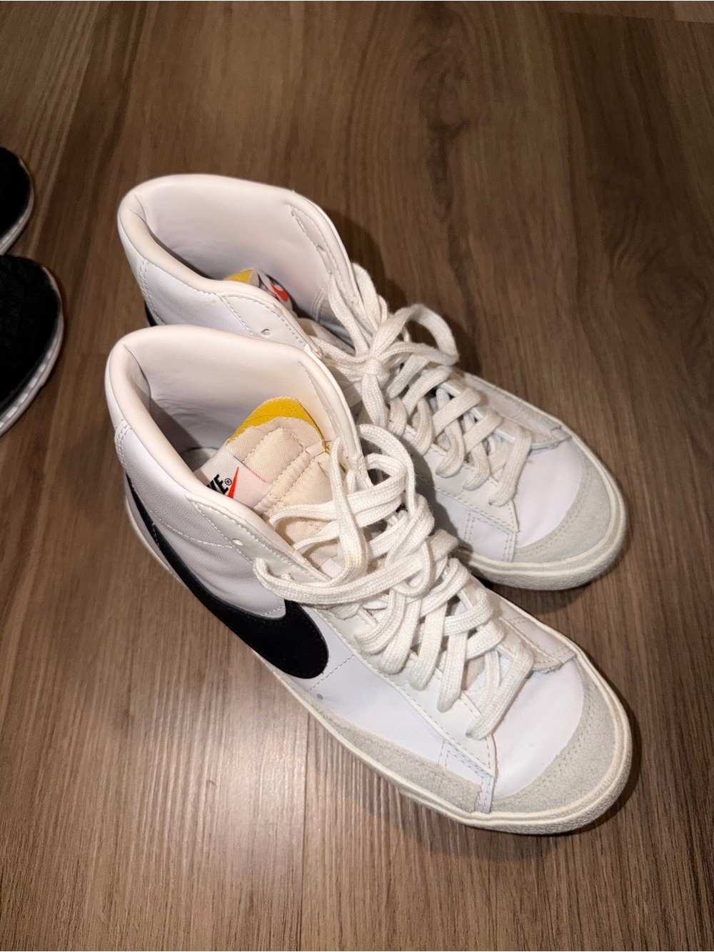 Nike White High-Top Sneakers with Black Swoosh and Yellow Tongue Accent